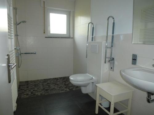 a white bathroom with a toilet and a sink at Ferienwohnung Hermann Miß in Bad Berleburg