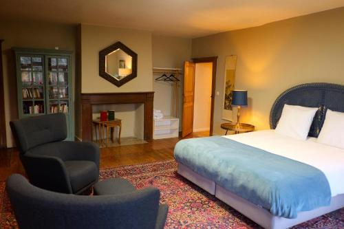 a bedroom with a bed and a chair and a mirror at Au Petit Bercail - 2 Chambres d'hôtes pour 2 personnes in Chiny