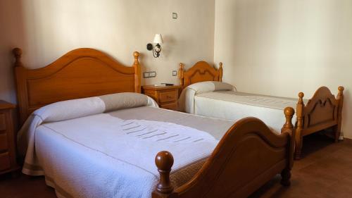 a bedroom with two beds with white sheets at Casa Mola in Forcall
