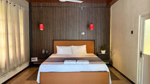 a bedroom with a bed with two towels on it at Forest Garden Cottages in Deraniyagala