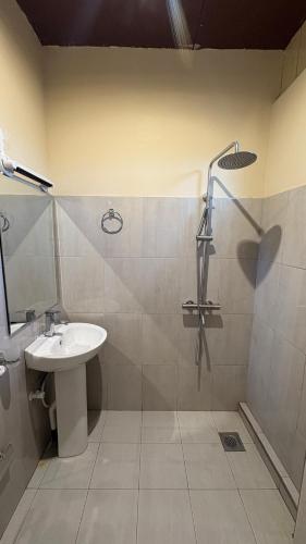 a bathroom with a sink and a shower at Forest Garden Cottages in Deraniyagala