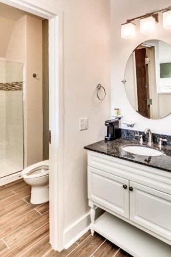 a bathroom with a sink and a toilet and a mirror at The Inn at Shattuck - St. Mary's in Faribault
