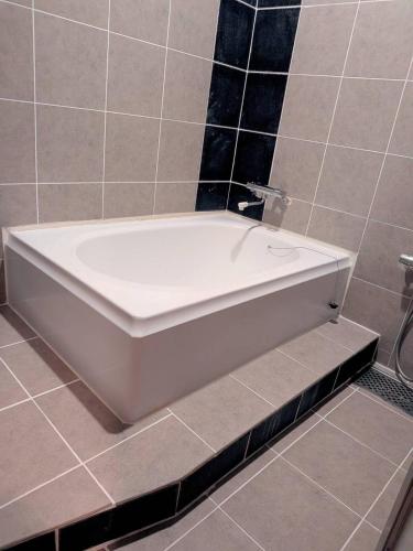 a white bath tub sitting in a bathroom at ビジネスホテルヴｨ in Kakogawa