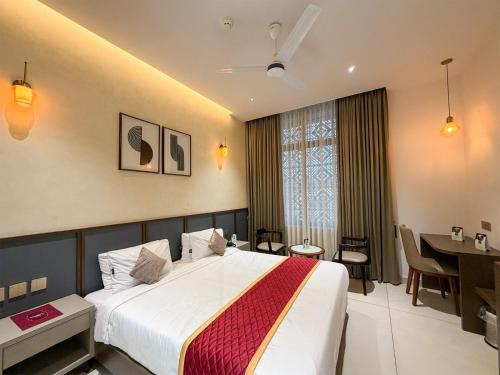 a hotel room with a bed and a dining room at Hotel Grand Residency in Mannārakkāt