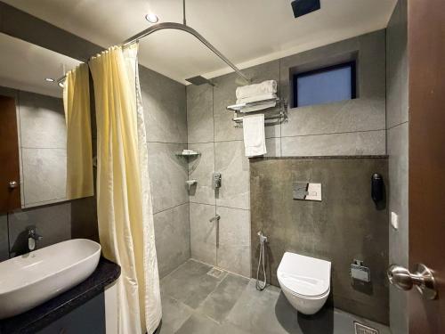 a bathroom with a shower and a toilet and a sink at Hotel Grand Residency in Mannārakkāt