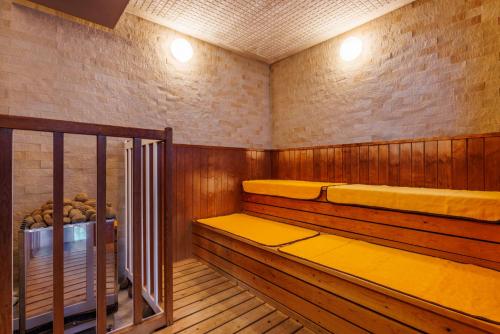 a sauna with wood paneling and yellow cushions at Biwako Grand Hotel Kyo-Ohmi in Otsu