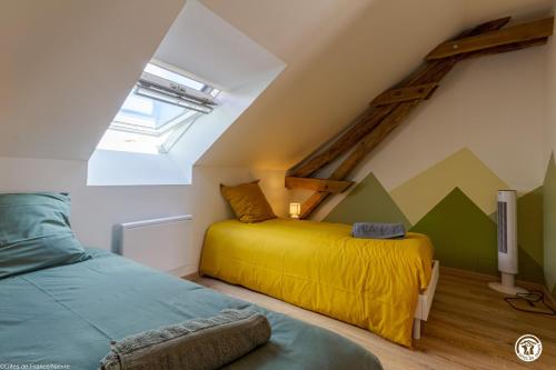 a bedroom with two beds in a attic at Gîte de Savenay in Aunay-en-Bazois