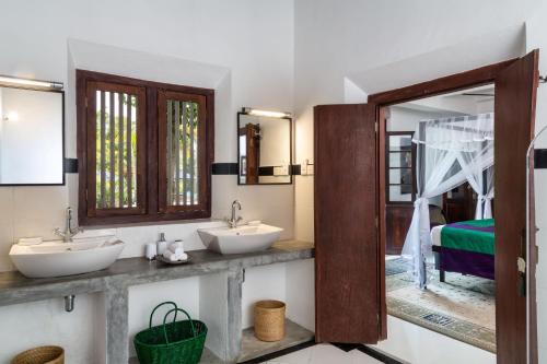 a bathroom with two sinks and a mirror at Clingendael Weligama in Weligama