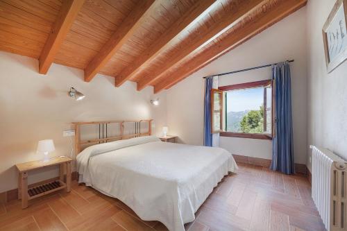 a bedroom with a large bed and a window at Villa Es Barracar Caimari in Caimari