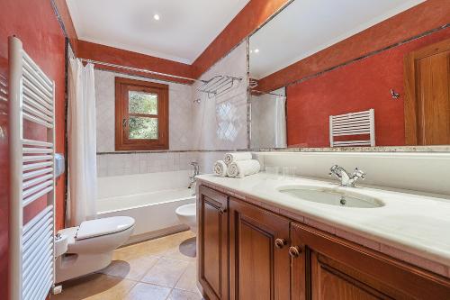 a bathroom with a sink and a toilet and a mirror at Villa Es Barracar Caimari in Caimari