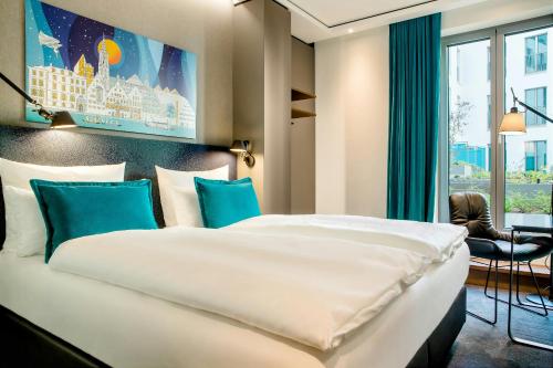 a hotel room with a bed and a window at Motel One Ulm in Ulm