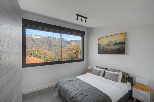 a bedroom with a bed and a large window at La Roche & Le Lac in Sévrier