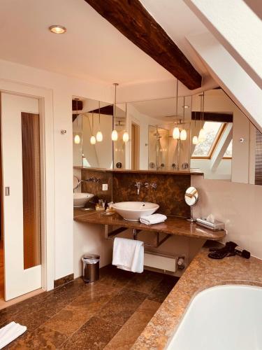 a bathroom with two sinks and a large mirror at Rebers Pflug in Schwäbisch Hall