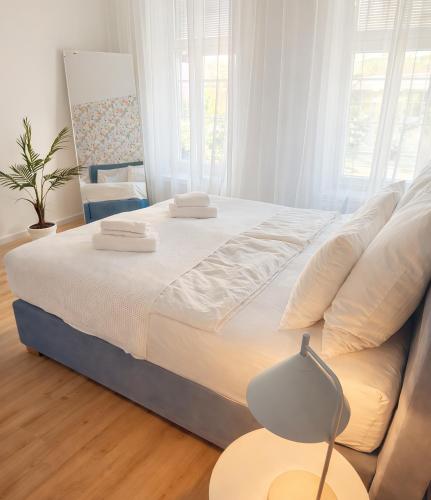 a bedroom with a large bed and a table with a lamp at Suites in Brunn am Gebirge in Brunn am Gebirge