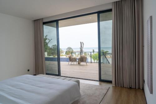 a bedroom with a bed and a view of a deck at Xanadu International Resort in Koh Rong Sanloem