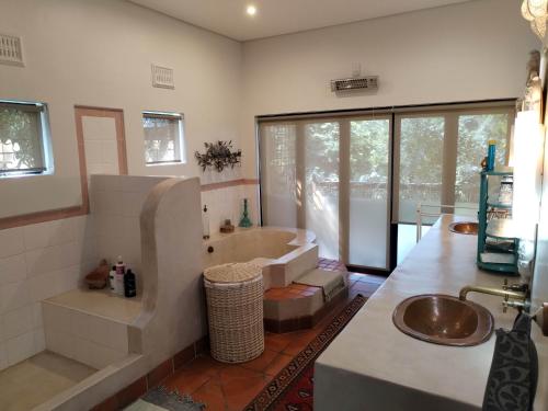 a bathroom with a tub and a sink at Le Chemin Guesthouse - 6 sleeper in Kloof