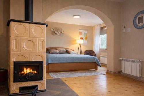 a bedroom with a fireplace in front of a bed at Matea Slow Living Home Private Retreat in Čortanovci