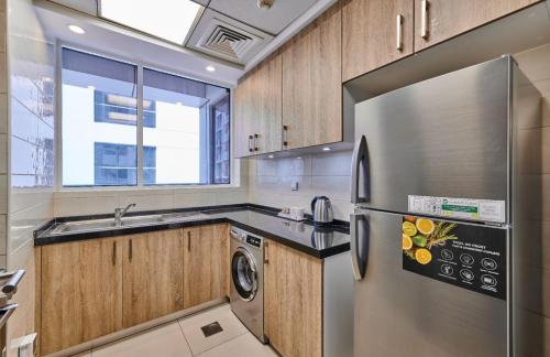 a kitchen with a stainless steel refrigerator and a dishwasher at Grand Stay Holiday Homes Rental 2 in Dubai