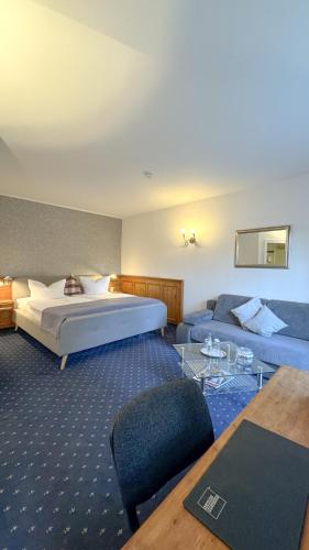 a hotel room with a bed and a couch at Hotel Haus Gimken in Essen