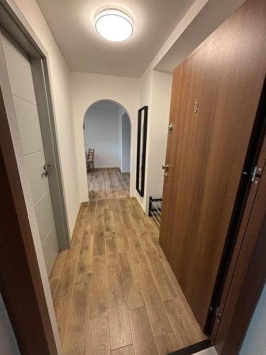 a hallway leading to a room with a door and wooden floor at Hrabůvka Living in Ostrava