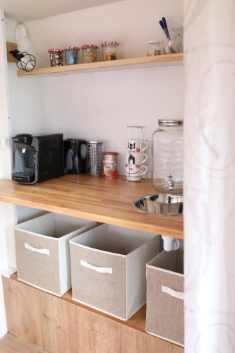Caravane cocooning في Saint-Martin-des-Noyers: رف مطبخ عليه صناديق كرتونية