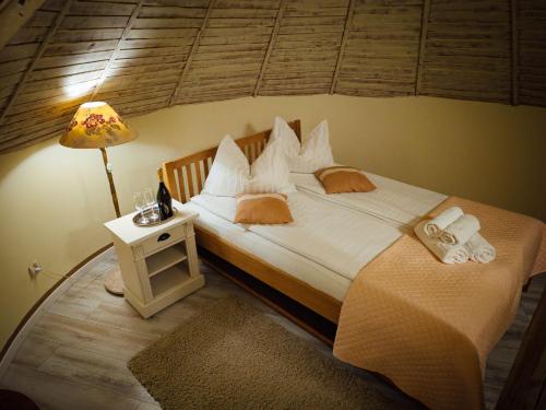 a bedroom with a large bed with a lamp and towels at Pensiunea Edy Turda in Turda