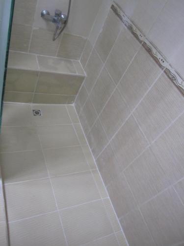 a shower in a bathroom with white tile at العين الهيلي مصباح بيت14 in Al Ain