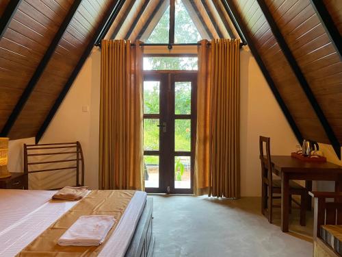 a bedroom with a bed and a large window at Yashi's Place Sigiriya in Sigiriya