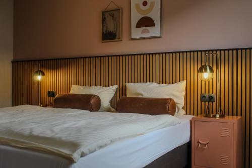a bedroom with a large bed with two chairs at Airport Hotel Jägerhof Weeze in Weeze