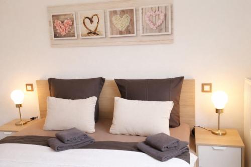 a bedroom with a bed with white pillows and two lamps at Ole's BergSuite in Braunlage
