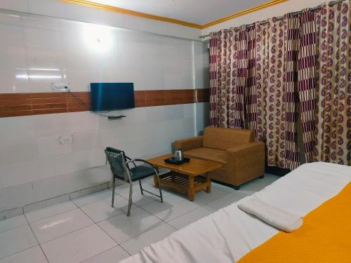 a room with a bed and a chair and a table at S D palace in Dighori