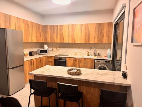 a kitchen with wooden cabinets and a large island at Niko's Modern Family Home near the Beach in Limassol