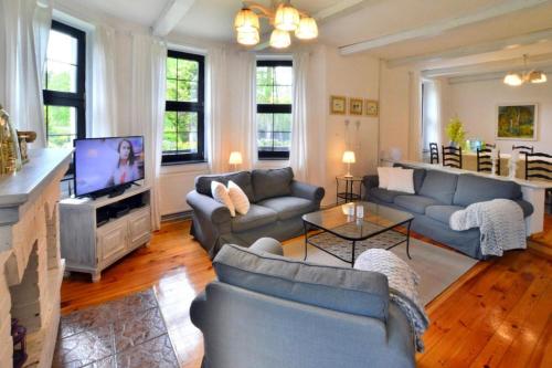 a living room with blue couches and a television at Holiday home, oasis of peace, Polanow in Pollnow