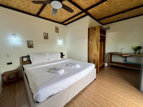 a bedroom with a large white bed and a table at Lanta Baan Suan Yoo Dee in Ban Nong Chaeng