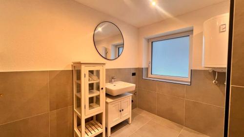 a bathroom with a sink and a mirror at Apart Alm in Karrösten