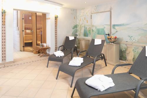 a waiting room with four chairs and a mirror at Hotel Haus Gimken in Essen