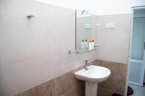 a bathroom with a sink and a mirror at Rainforest Jungle Chill Singharaja in Deniyaya
