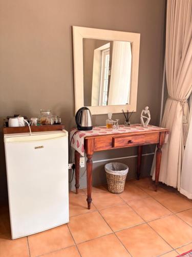 a bathroom with a wooden table and a mirror at Soeterus Guest Farm in Calitzdorp