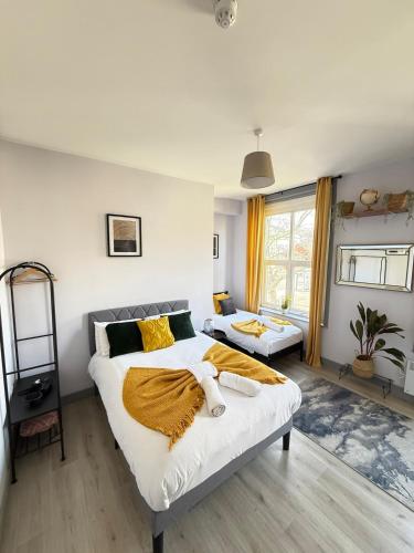 a bedroom with a large white bed with yellow sheets at The Wolfs Tavern in London