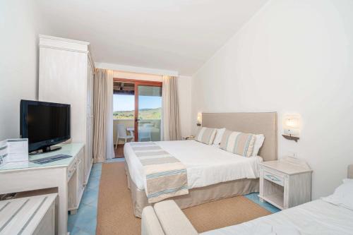 a hotel room with a bed and a television at Hotel Sa Pedra in Murta Maria