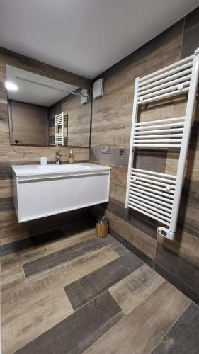 a bathroom with a large white tub and wooden floors at Chambre Privée avec Sauna in Villeneuve-Loubet