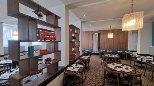a restaurant with tables and a red bus on the wall at Lancaster Hall Hotel in London