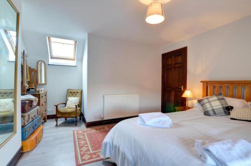 a bedroom with a large white bed and a chair at 2 Bed in Porthcawl oc-way245 in Porthcawl