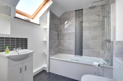 a bathroom with a tub and a sink and a shower at 2 Bed in Porthcawl oc-way245 in Porthcawl