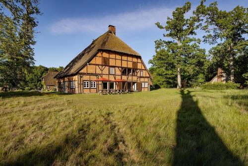 a long shadow of a house in a field at Haus im Wald in Gartow
