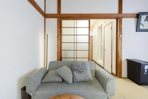 a living room with a couch and a tv at Kawagoe Good Place Apartment in Kawagoe