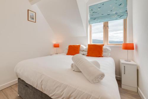 a bedroom with a large white bed with orange pillows at 2 Bed in Aberdyfi oc-wah694 in Aberdyfi
