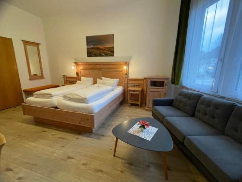 a bedroom with a bed and a couch and a table at Dom-Hotel in St. Blasien