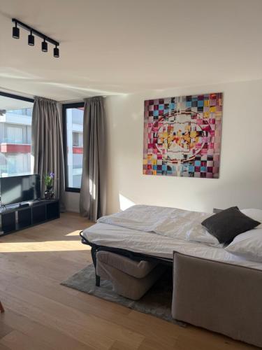 a bedroom with a bed and a painting on the wall at Live Lugano - Via Muggina in Viganello