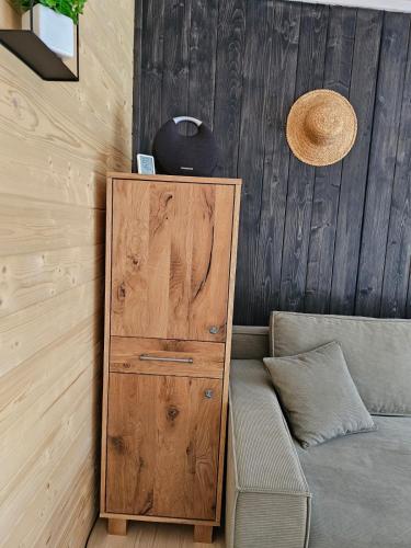 a wooden cabinet next to a couch in a room at Модрина Космач ko kosmach in Kozmacz
